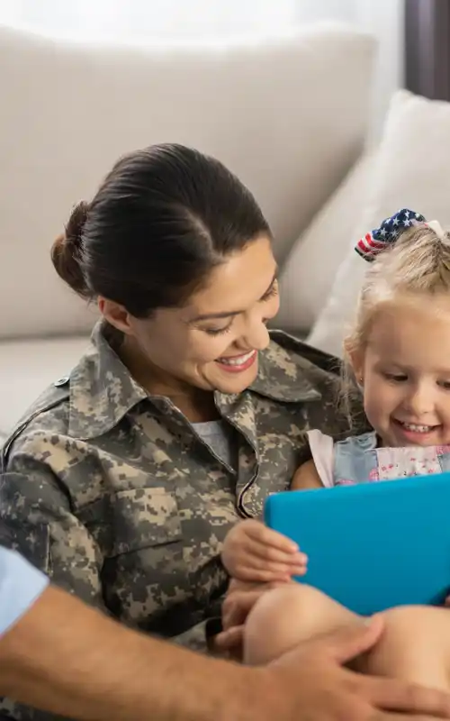 Military woman watching cartoon with daughter and husband