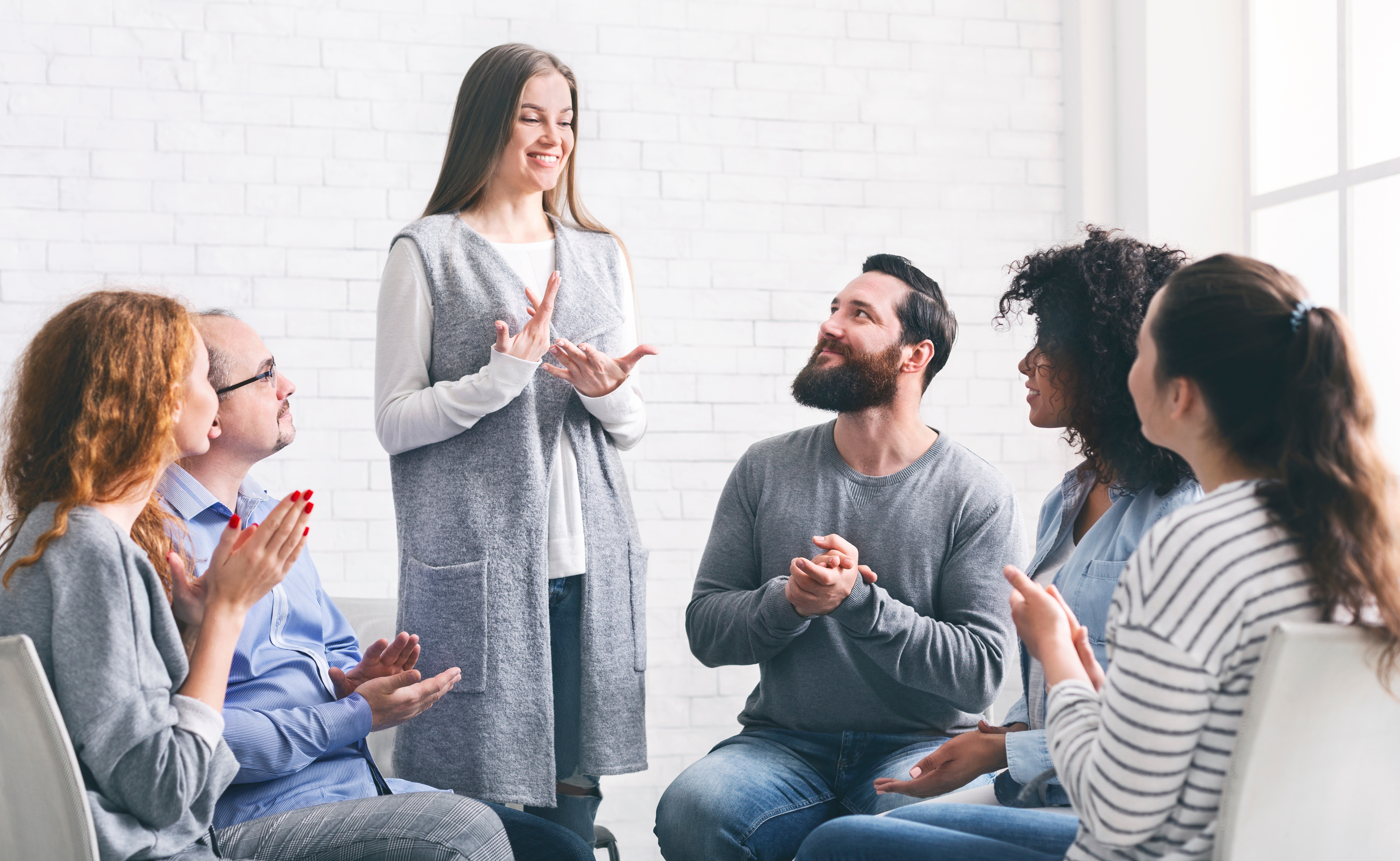 A woman talking to a group therapy session