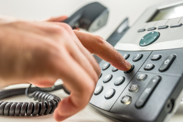Man pushing button on office phone