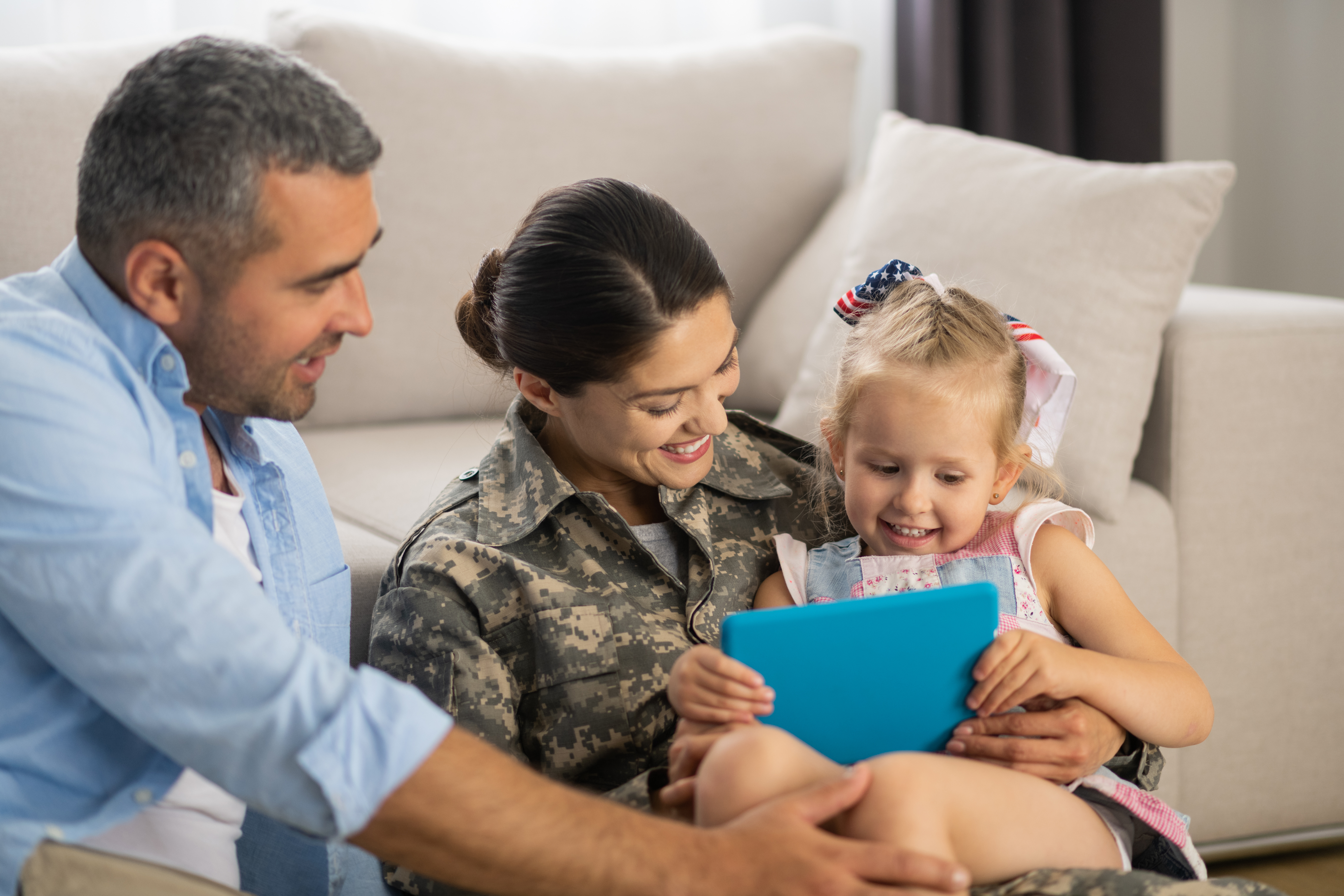 Military woman watching cartoon with daughter and husband