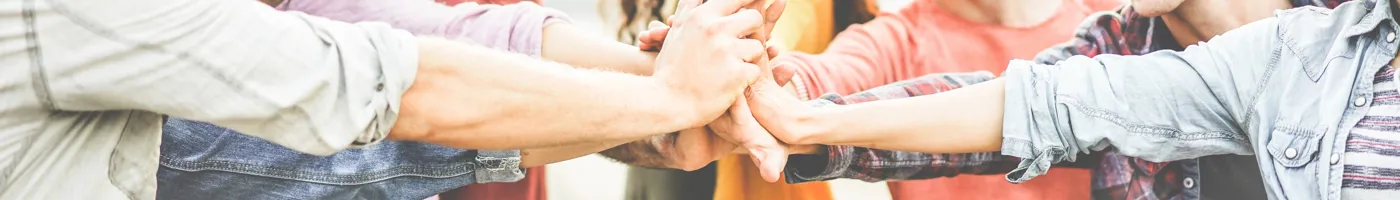 A group of people placing their hands together