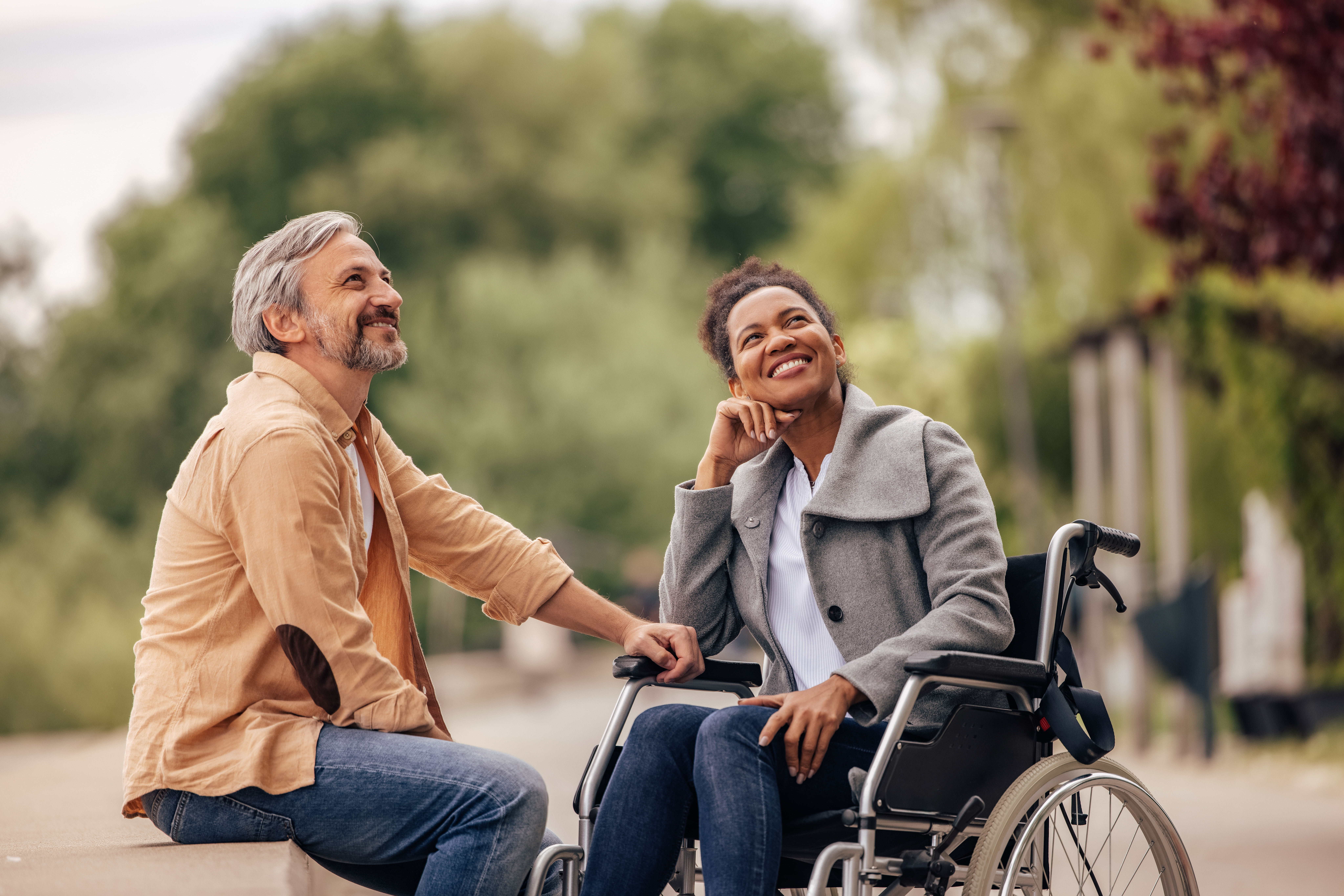A happy couple where a man is placing his hand on the thigh of his wife in a wheelchair