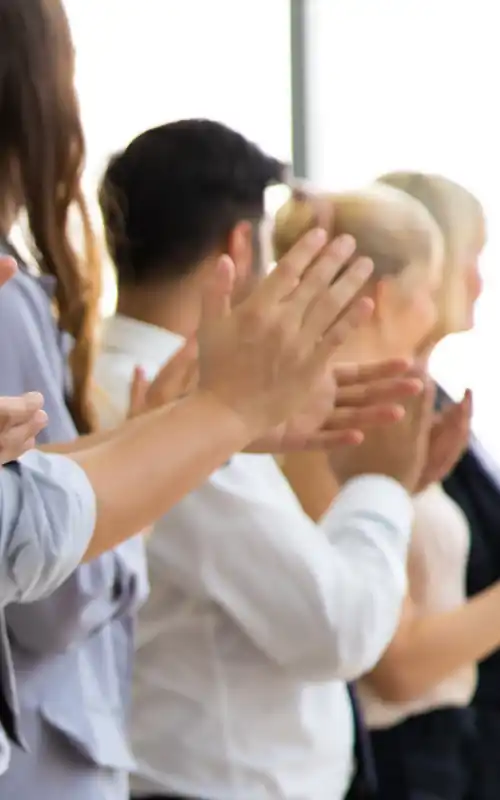 A group of employees clapping their hands together in approval