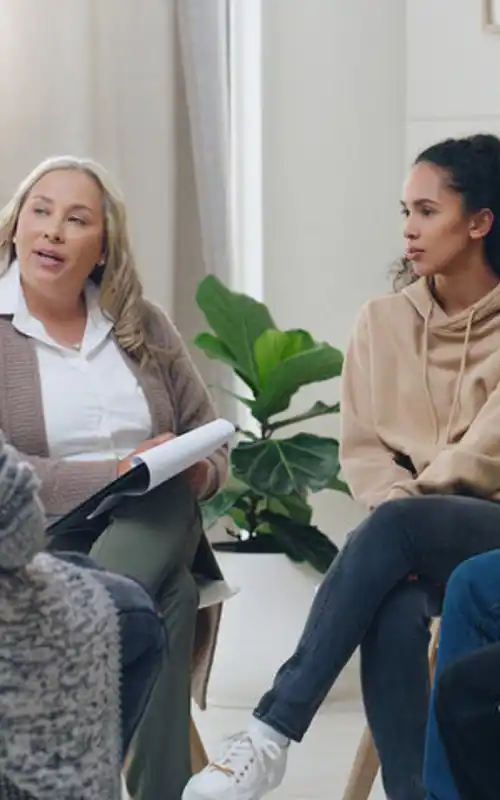 A group of diverse clients sitting in a circle in group therapy