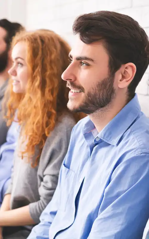 Two men and two women sitting and smiling in the same direction