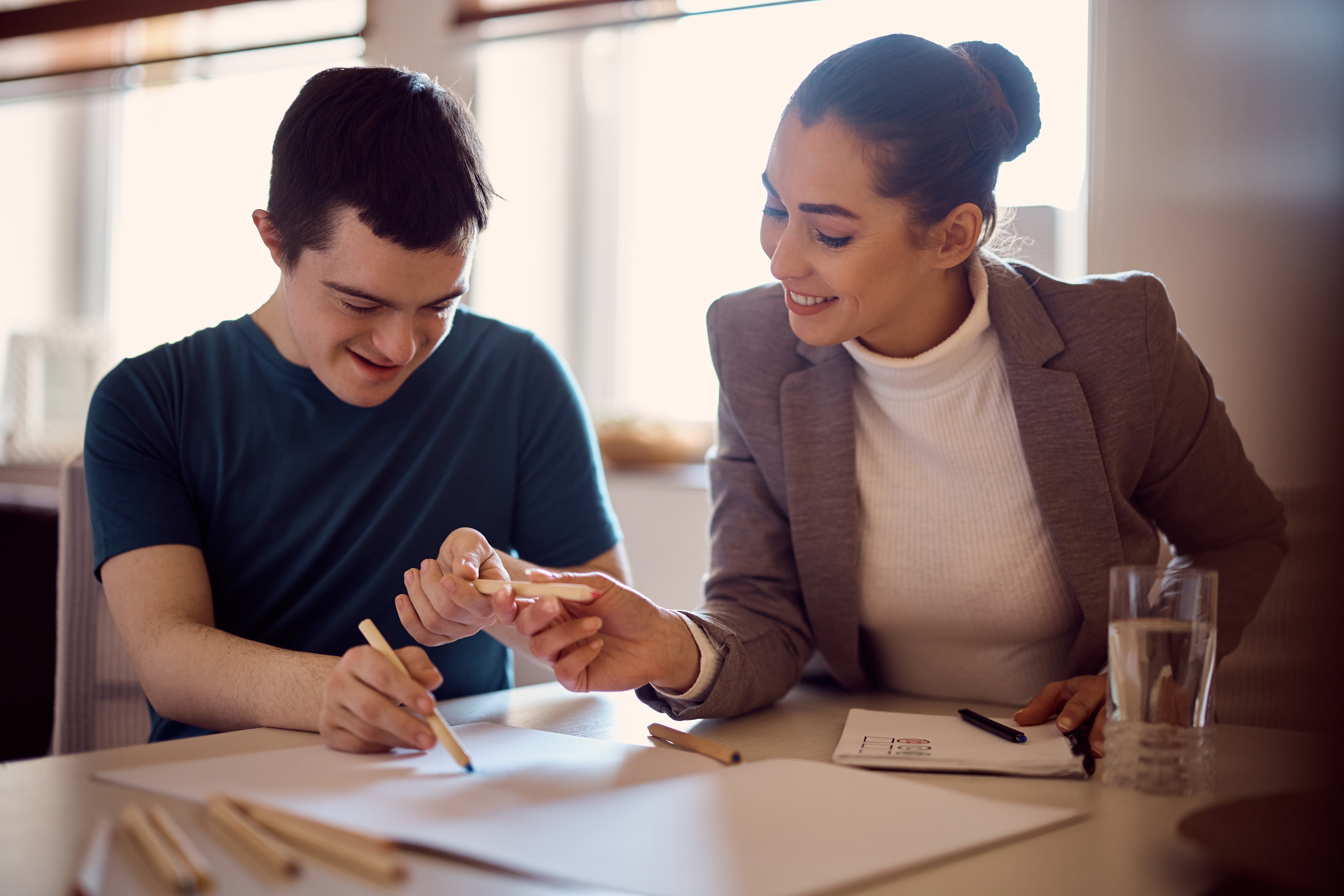 A young disabled man working with an older woman through sessions