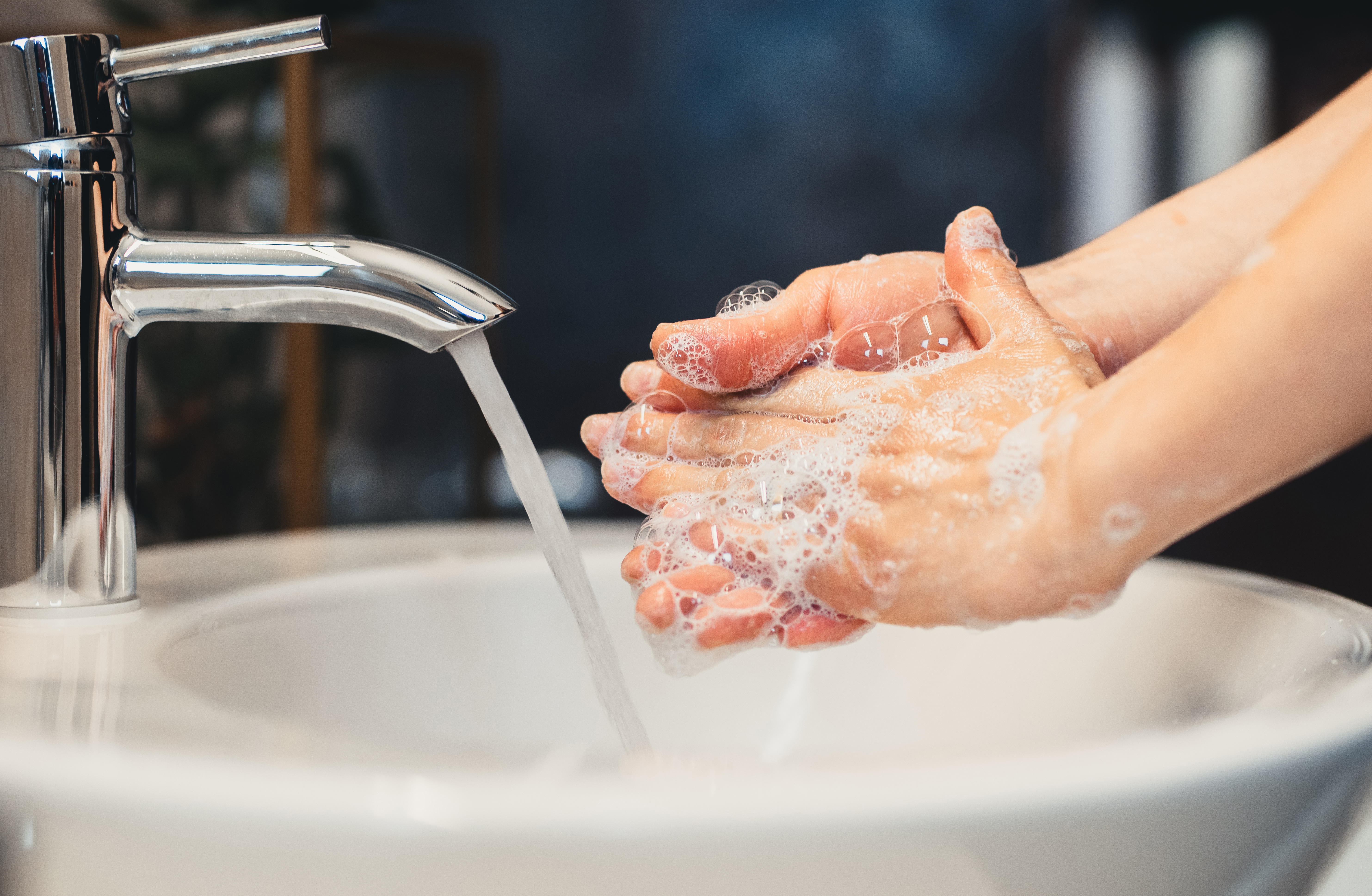 A person scrubbing their hands in the sink