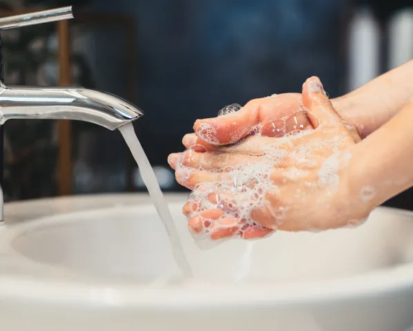 A person scrubbing their hands in the sink