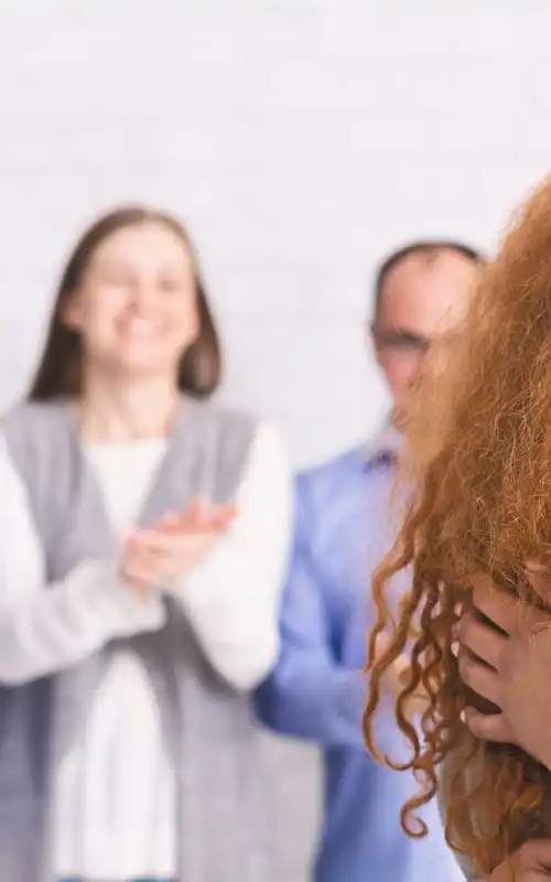 A red headed girl hugging a curly headed girl