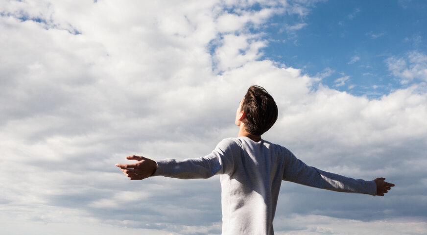 A man basking in the sunlight and gazing at the clouds