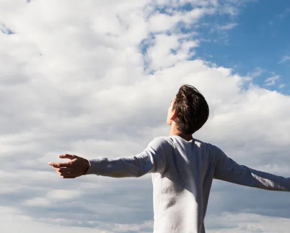 A man basking in the sunlight and gazing at the clouds