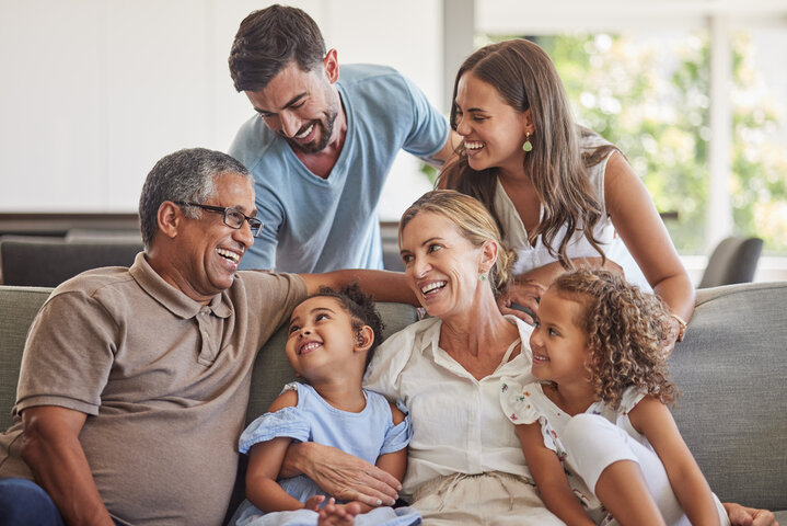 family sitting on couch smiling and laughing