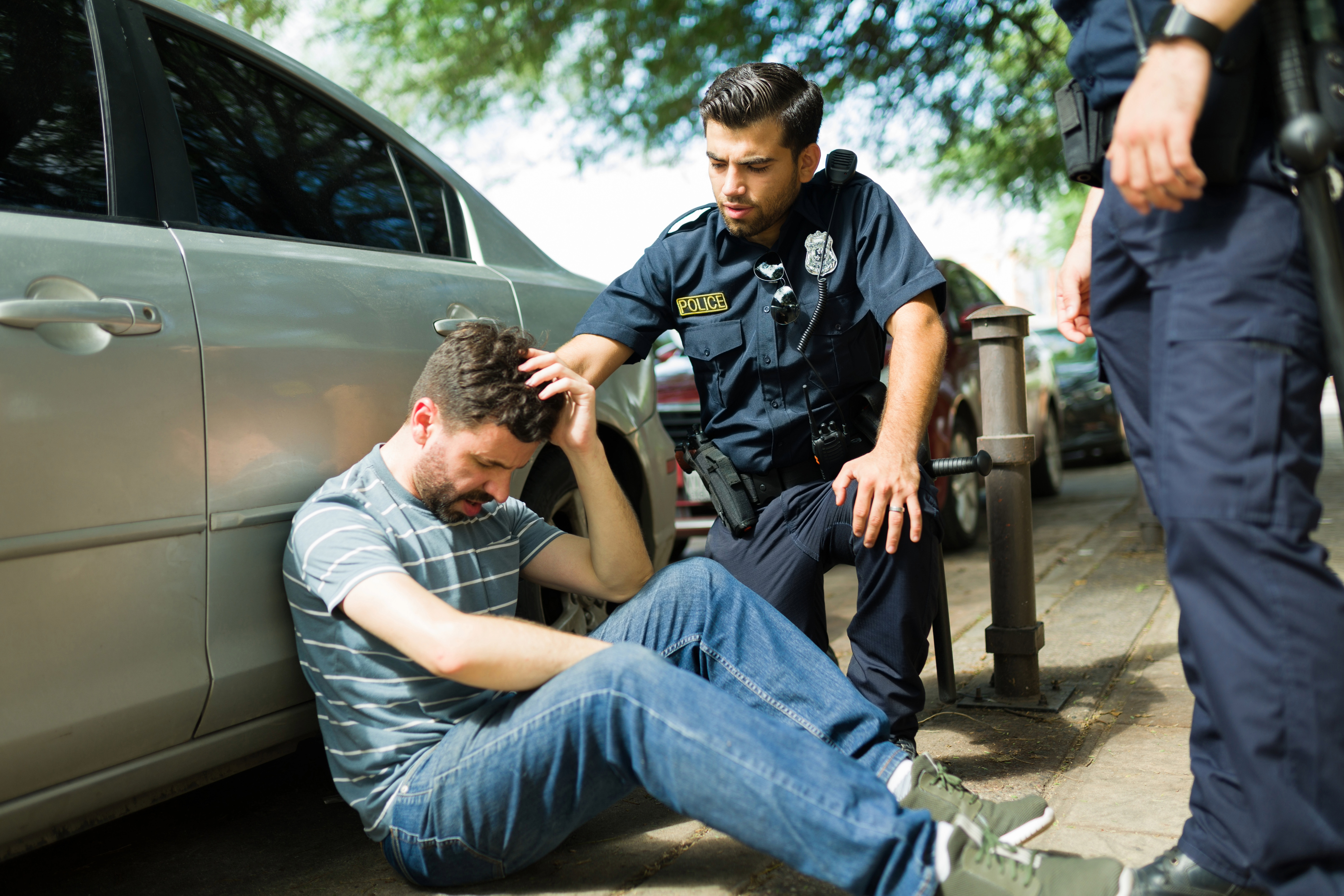 Officer assisting distressed man on the curb