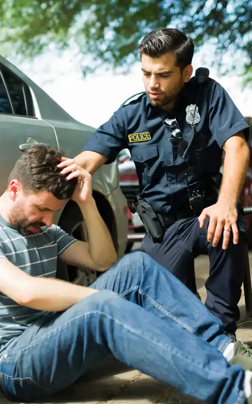 Officer assisting distressed man on the curb