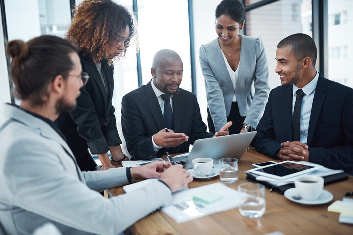 A group of diverse individuals sitting in a board room and elevating their career