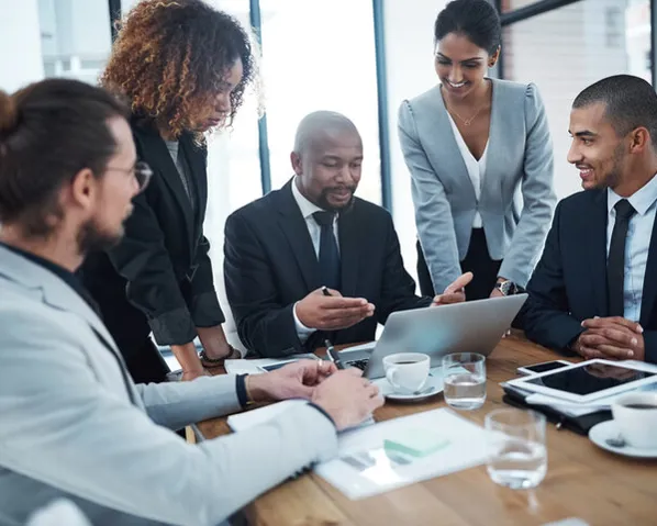 A group of diverse individuals sitting in a board room and elevating their career