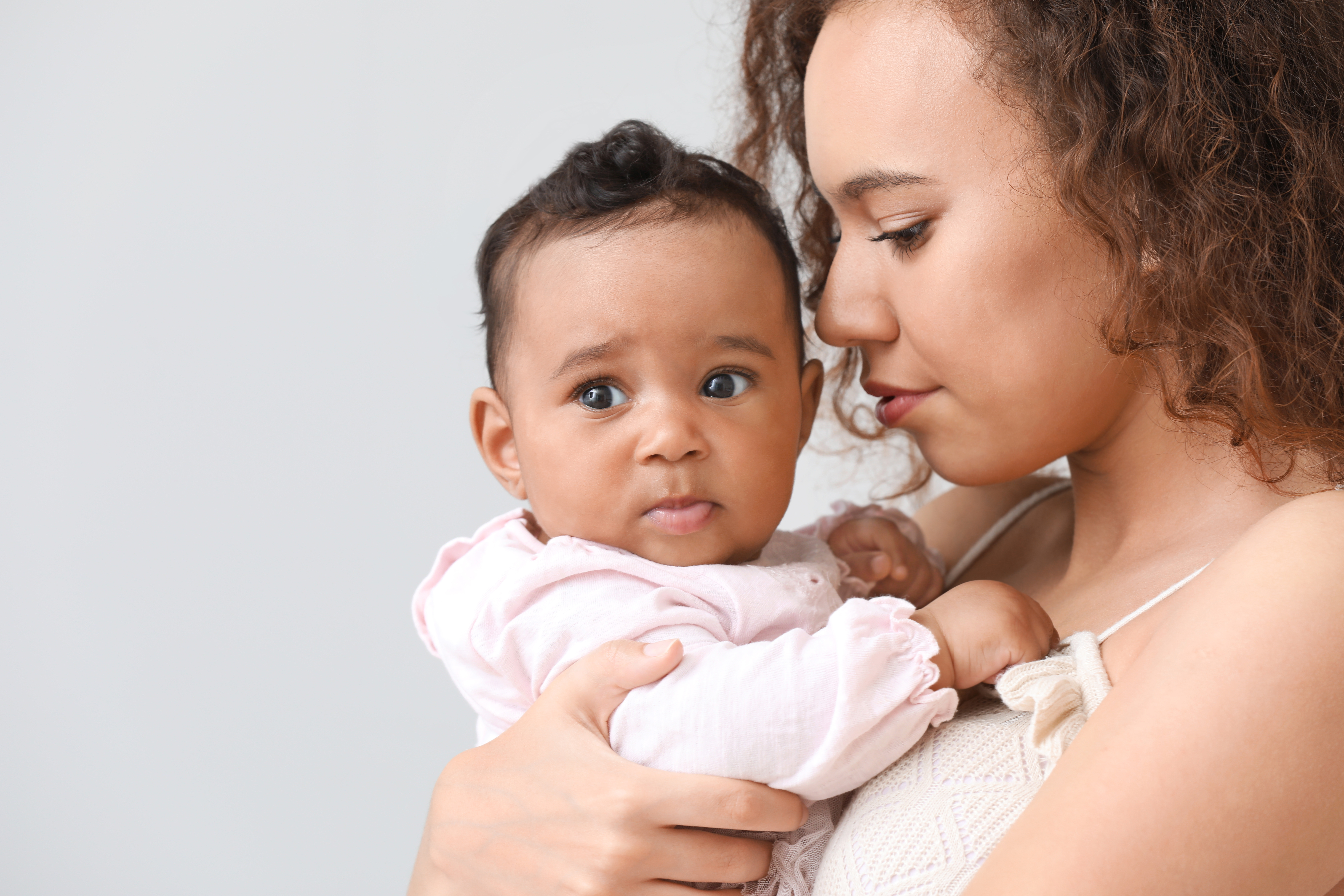A woman holding her young baby close