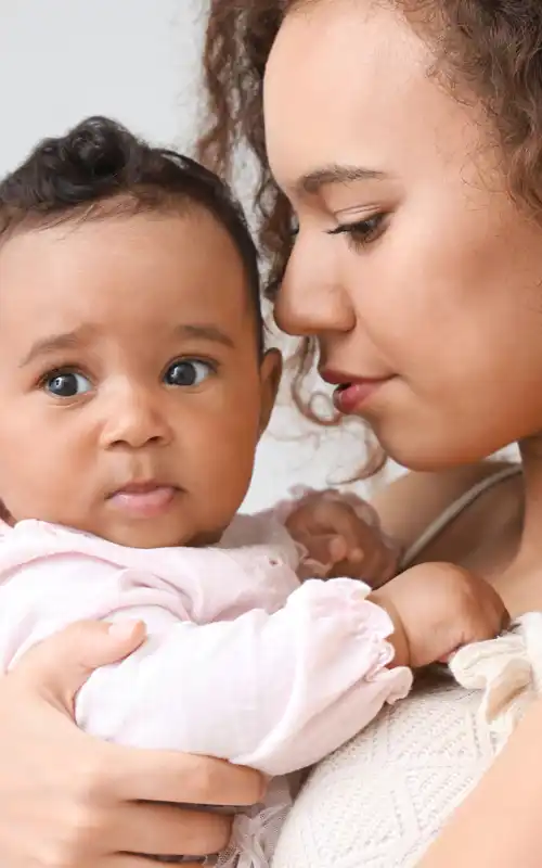 A woman holding her young baby close